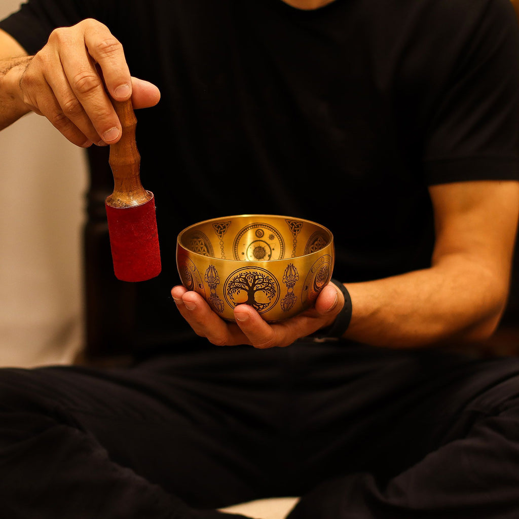 Personne utilisant un bol chantant tibétain avec un maillet pour produire des vibrations apaisantes