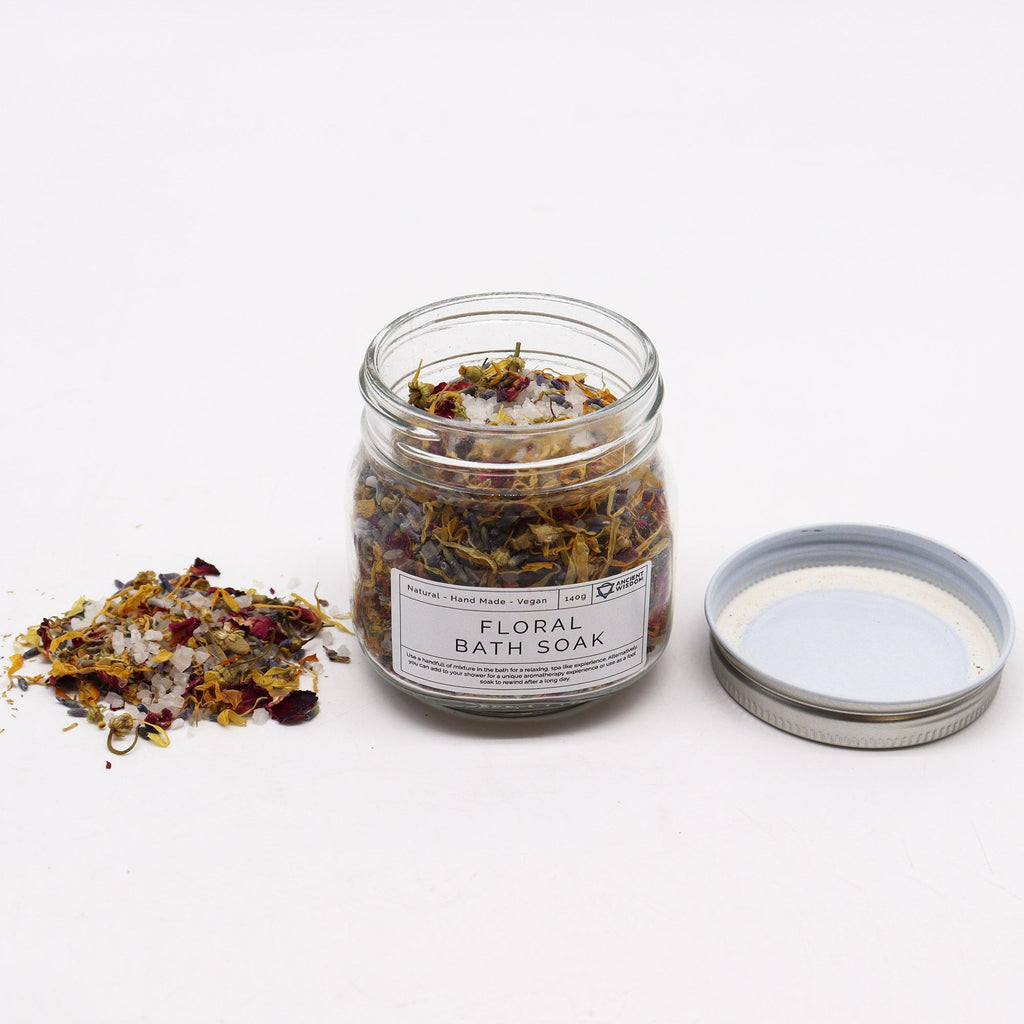 bain floral naturel aux plantes botaniques dans un pot en verre pour rituel de relaxation. Pot ouvert avec un couvercle à côté du pot et bain floral éparpillé de l'autre côté
