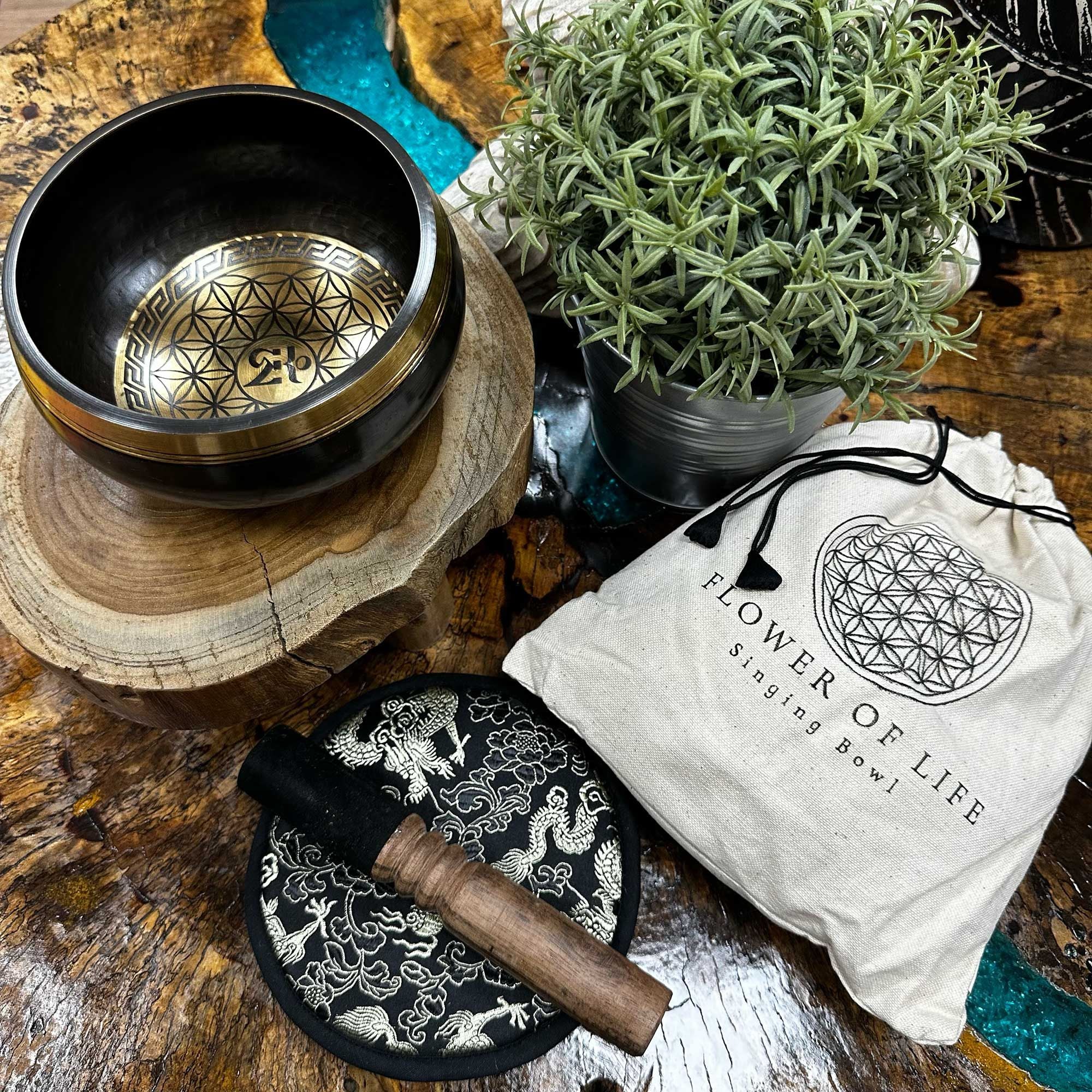 Bol chantant gravé Fleur de Vie avec accessoires sur surface naturelle, utilisé pour relaxation, méditation et équilibre énergétique