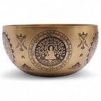 Vue latérale d’un bol chantant tibétain en laiton avec motifs gravés et symbole Om
