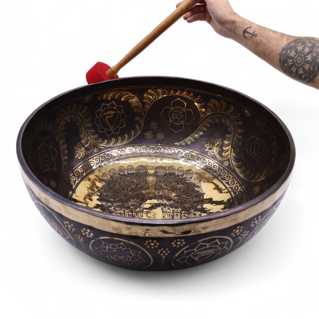 Grand bol chantant tibétain utilisé avec maillet rouge, vibration sonore et relaxation