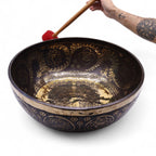 Grand bol chantant tibétain utilisé avec maillet rouge, vibration sonore et relaxation