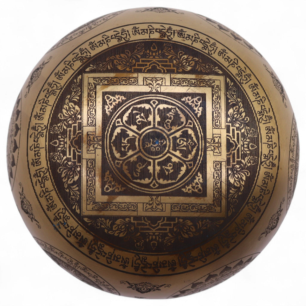 Détail du dessous d’un bol chantant tibétain avec gravure mandala et symboles spirituels