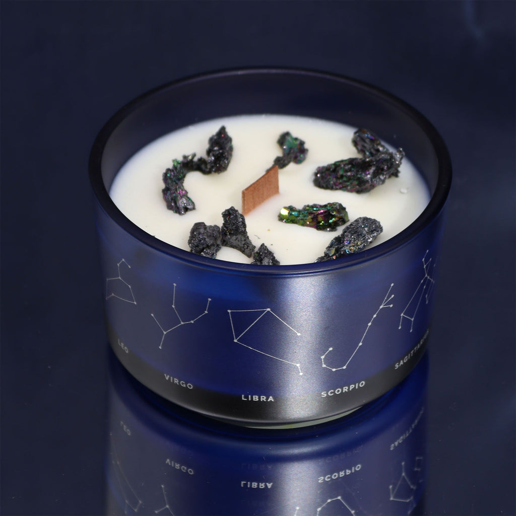 Bougie astrologique avec pierres naturelles, bois crépitant, parfum intense, dans un contenant décoré des constellations du zodiaque