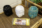 Brûleur Bouddha blanc utilisé avec pierres et accessoires bien-être, ambiance zen et relaxation