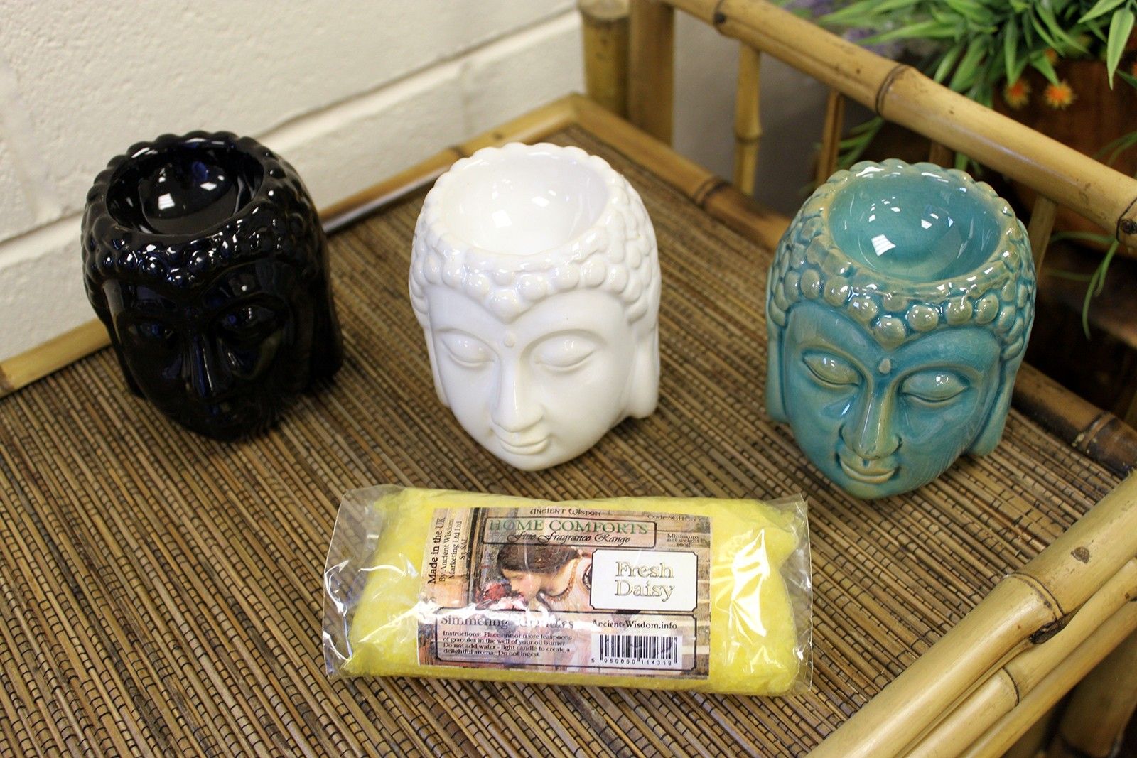 Brûleur Bouddha blanc utilisé avec pierres et accessoires bien-être, ambiance zen et relaxation