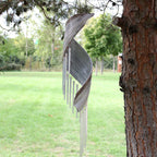 Carillon en feuille de coco whitewash suspendu dans un jardin, ambiance naturelle et relaxante