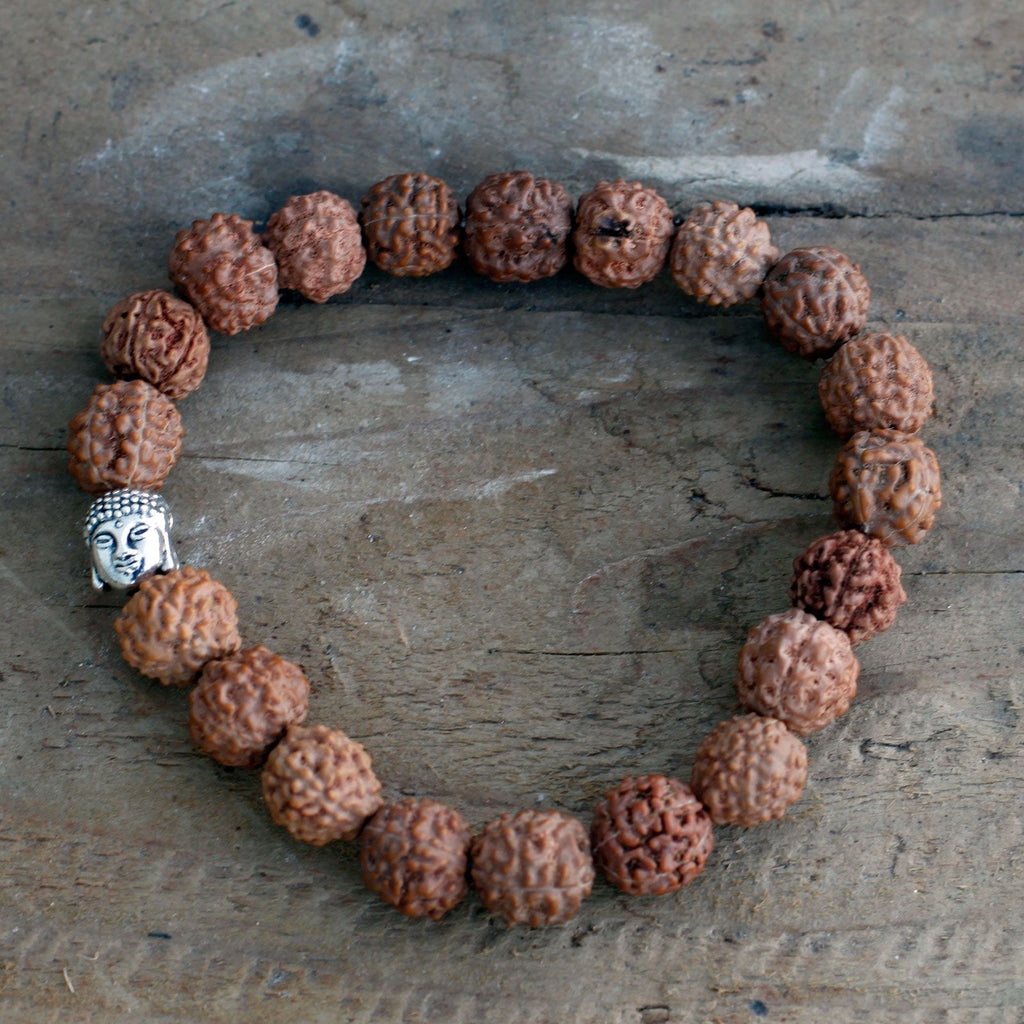 Gros plan sur les perles de rudraksha et la tête de Bouddha du bracelet mala marron