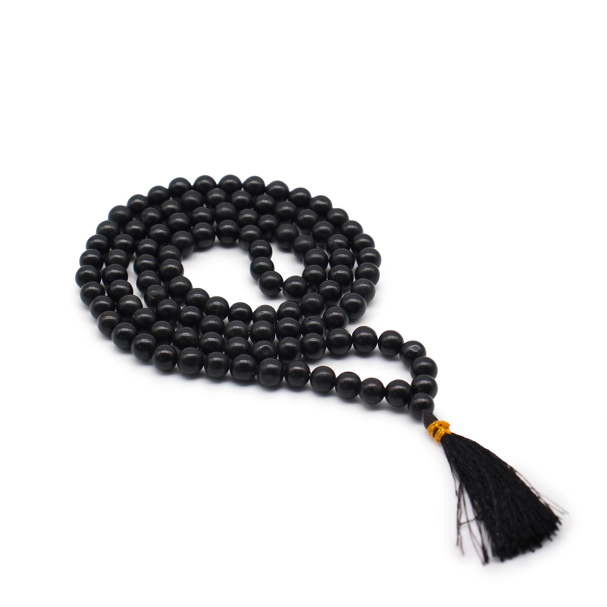 Mala 108 perles en pierre naturelle agathe noir avec pompon noir, collier de meditation en perles rondes pose sur fond blanc, bijou spirituel pour yoga et relaxation