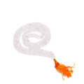 Mala 108 perles en pierre naturelle cristal de roche avec pompon orange, collier de meditation en perles rondes pose sur fond blanc, bijou spirituel pour yoga et relaxation