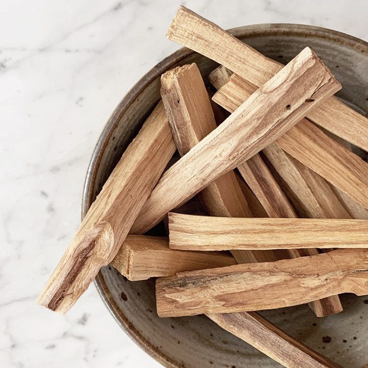 Bâtons de Palo Santo disposés dans un bol pour rituel de purification, méditation et relaxation