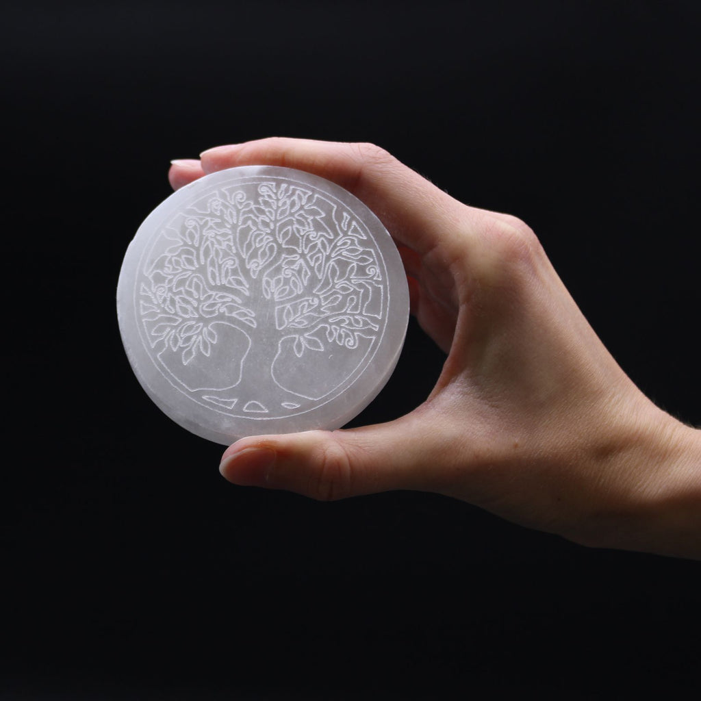 Plaque selenite arbre de vie tenue en main pour recharger les pierres et favoriser l ancrage et l evolution personnelle