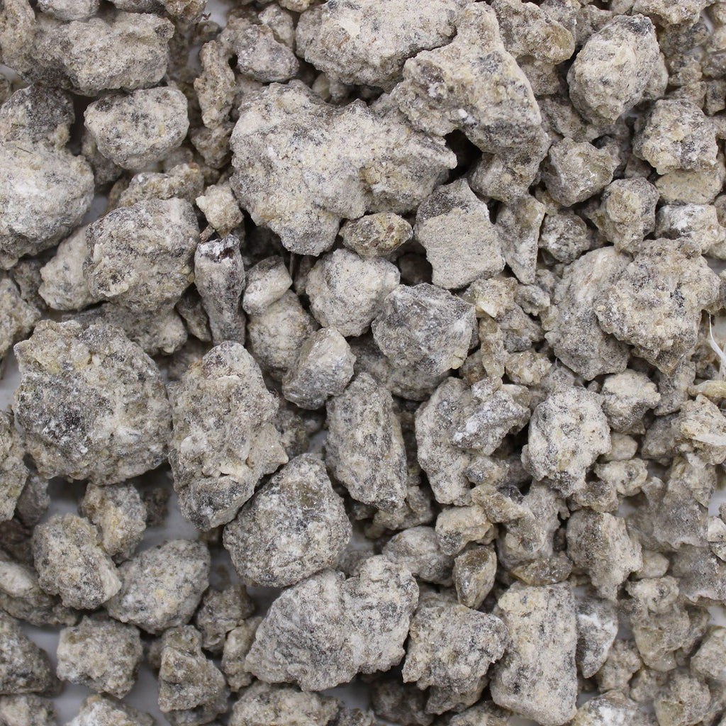 Gros plan sur des morceaux de résine de benjoin naturelle aux teintes blanc gris présentés en vrac
