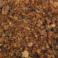 Gros plan sur des grains de résine de myrrhe brun doré en vrac, présenté en vrac