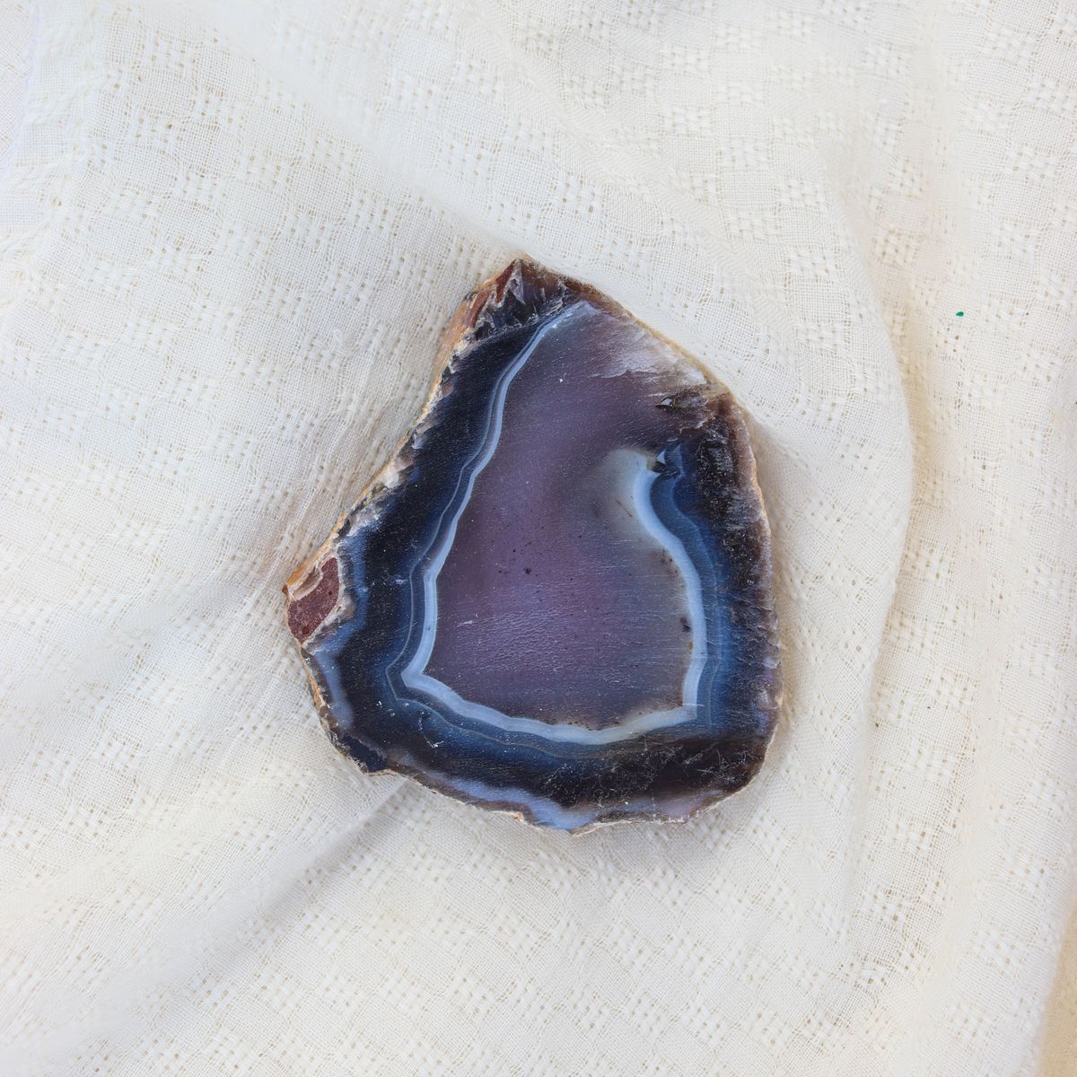 Tranche de géode d'agate bleue sur tissu blanc