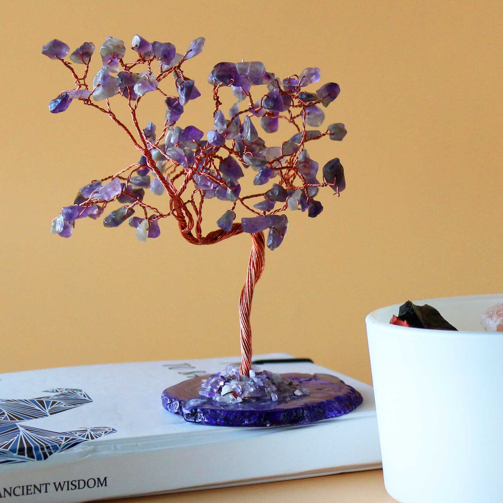 Arbre en améthyste posé sur une table avec lumière douce, idéal pour méditation et atmosphère relaxante