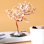 Arbre en pierres cristal de roche posé sur une table avec fond chaud, décoration énergétique minimaliste et apaisante
