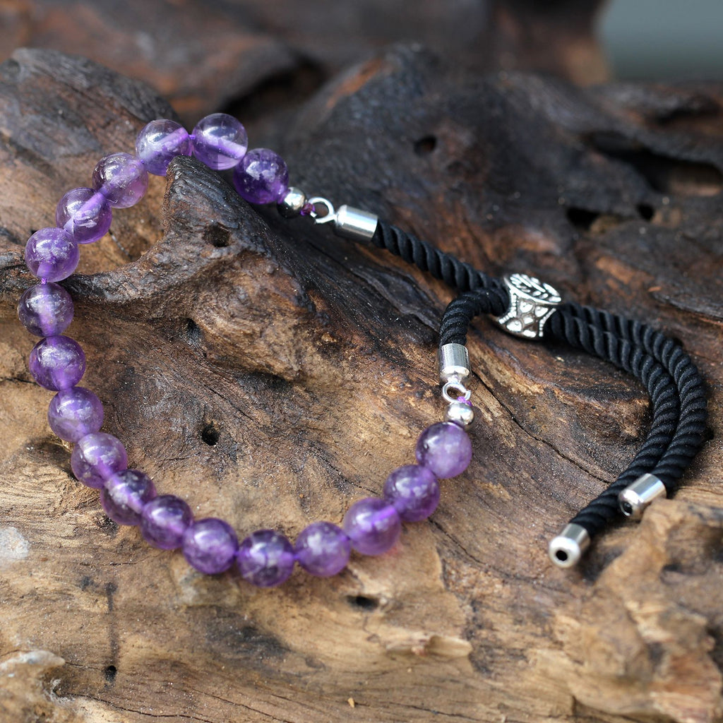Bracelet en pierre naturelle améthyste posé sur bois, symbole de sérénité et énergie spirituelle