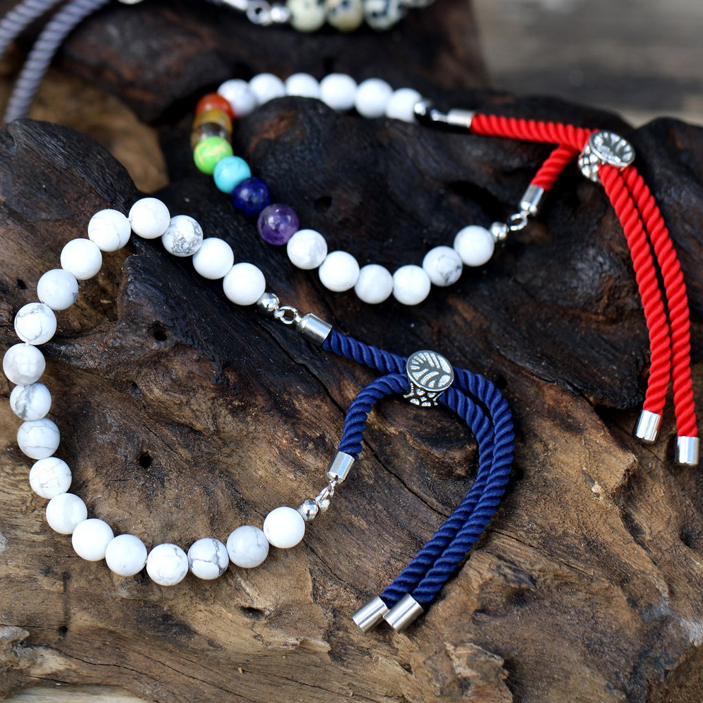 Bracelets en pierres naturelles ajustables avec cordons colorés et perles énergétiques sur support en bois