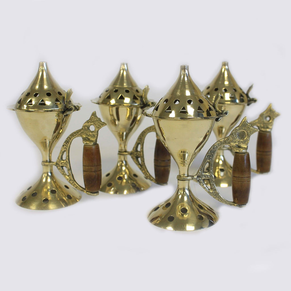 plusieurs brûleurs d’encens en laiton avec manche en bois alignés montrant le design traditionnel du brûleur pour cônes d’encens et rituels spirituels