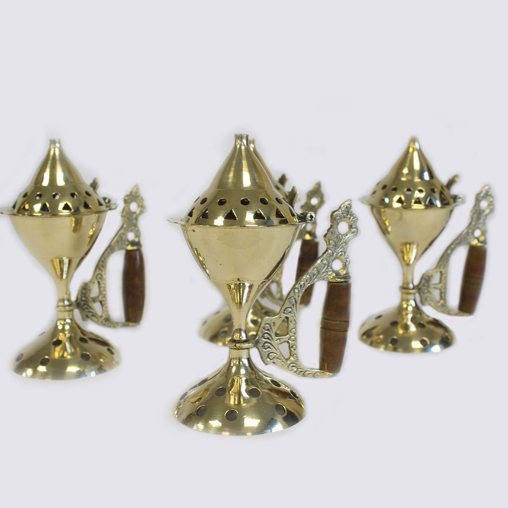 plusieurs brûleurs d’encens en laiton avec manche bois alignés montrant le design traditionnel du brûleur pour cônes d’encens