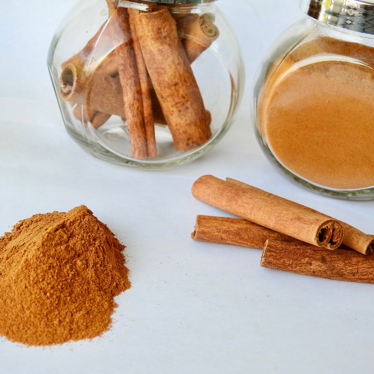 Bâtons et poudre de cannelle sur fond clair