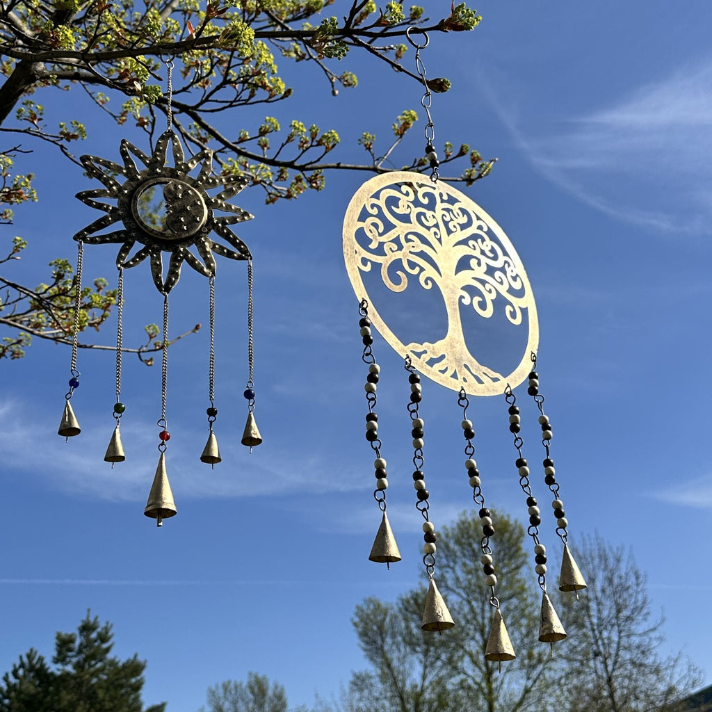 Carillon arbre de vie suspendu en extérieur dans un jardin, créant une ambiance apaisante et harmonieuse