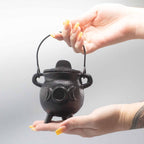 Chaudron rituel en fonte triple lune tenu en main, utilisé pour pratiques spirituelles et rituels énergétiques