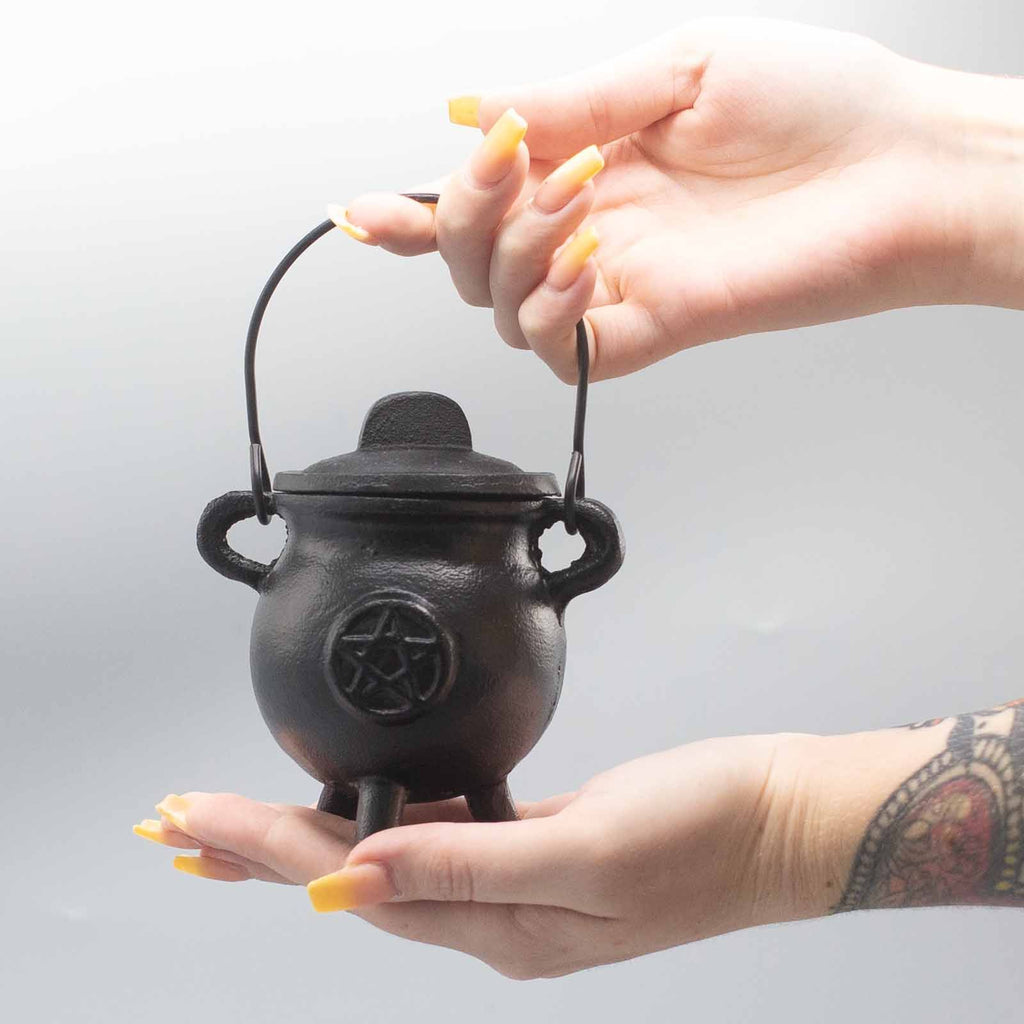 Chaudron rituel en fonte pentagramme tenu en main, utilisé pour pratiques spirituelles et rituels énergétiques