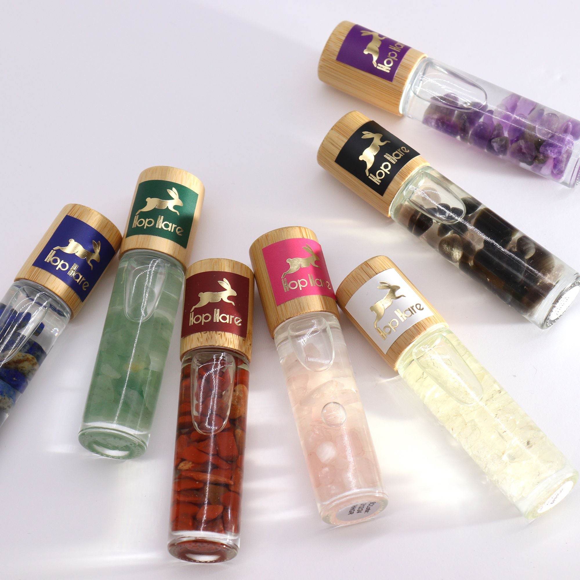 Collection de roll-on tarot aux huiles essentielles avec pierres naturelles pour le bien-être.