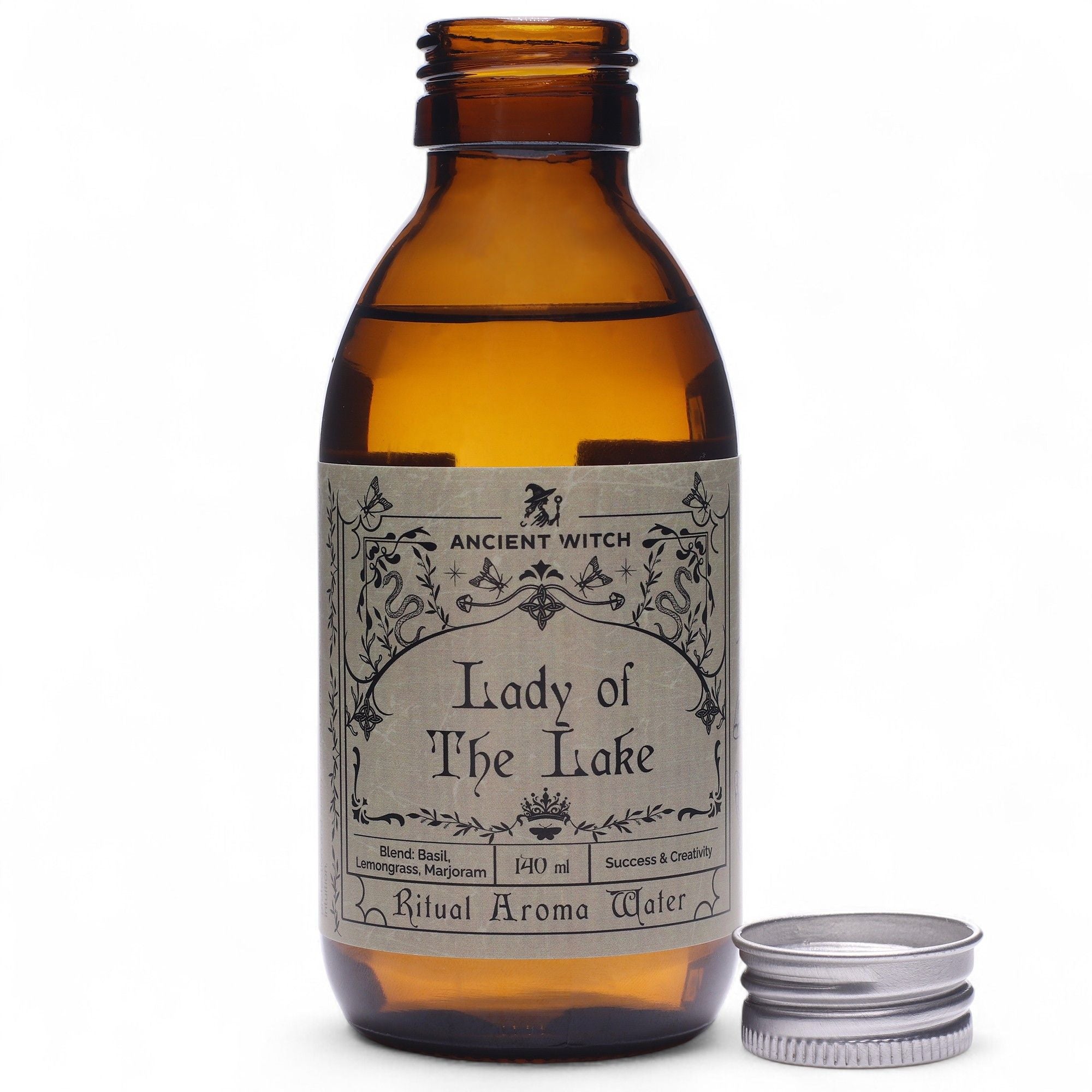 Eau rituelle dame du lac en flacon ambré avec bouchon posé à côté, utilisée pour les rituels énergétiques et la revitalisation