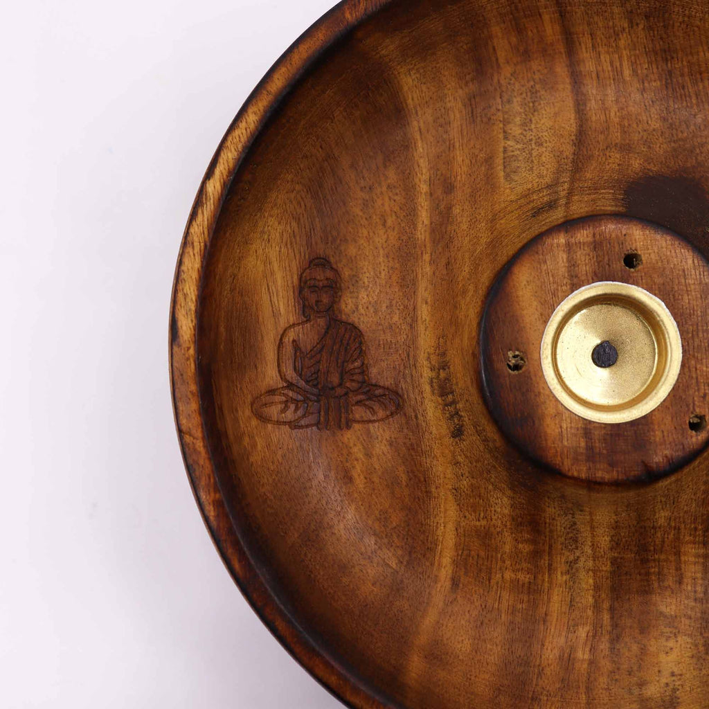 gros plan sur gravure bouddha en méditation sur un porte encens artisanal en bois naturel