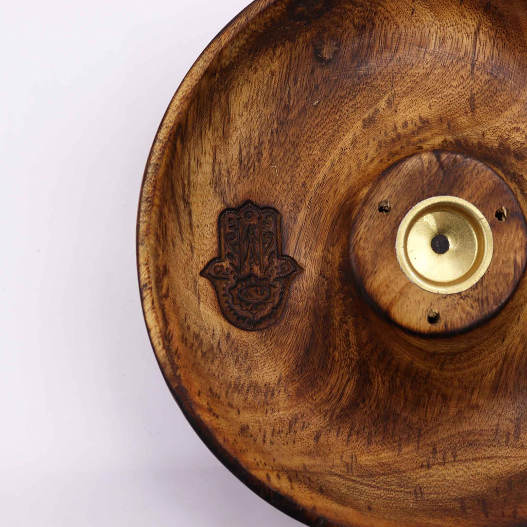 gros plan sur symbole hamsa gravé dans un porte encens en bois artisanal avec support central pour encens bâtons et cônes