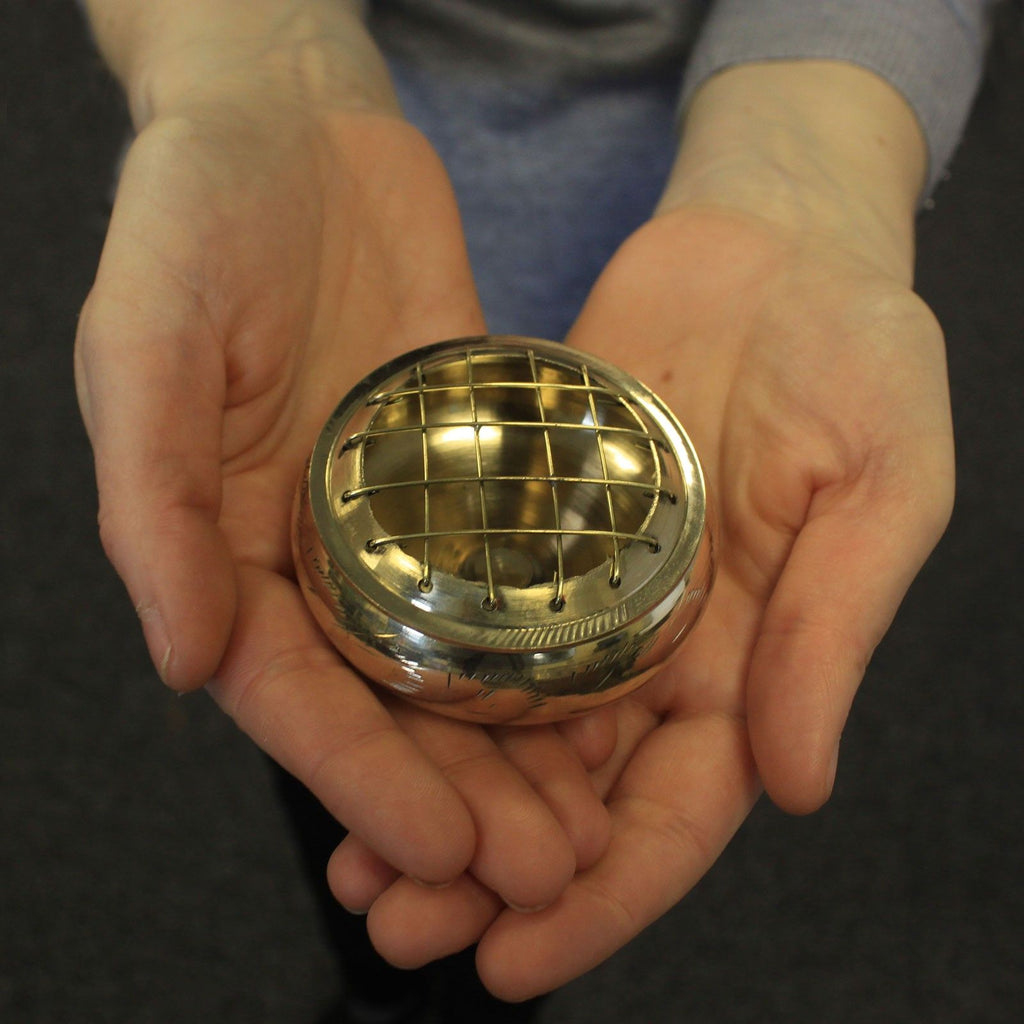 petit encensoir en laiton avec grille tenu dans les mains montrant sa taille compacte pour autel ou méditation