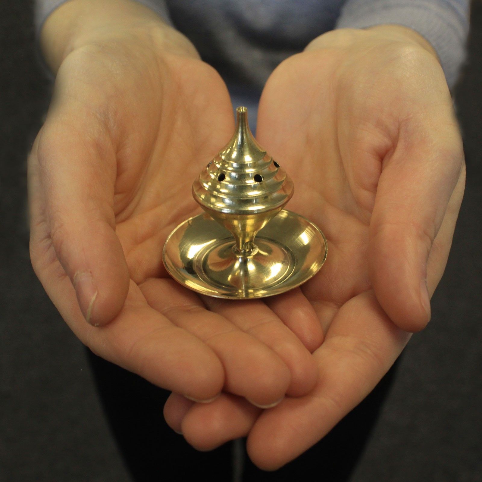 petit brûleur d encens en laiton tenu dans les mains montrant son format compact et son design traditionnel