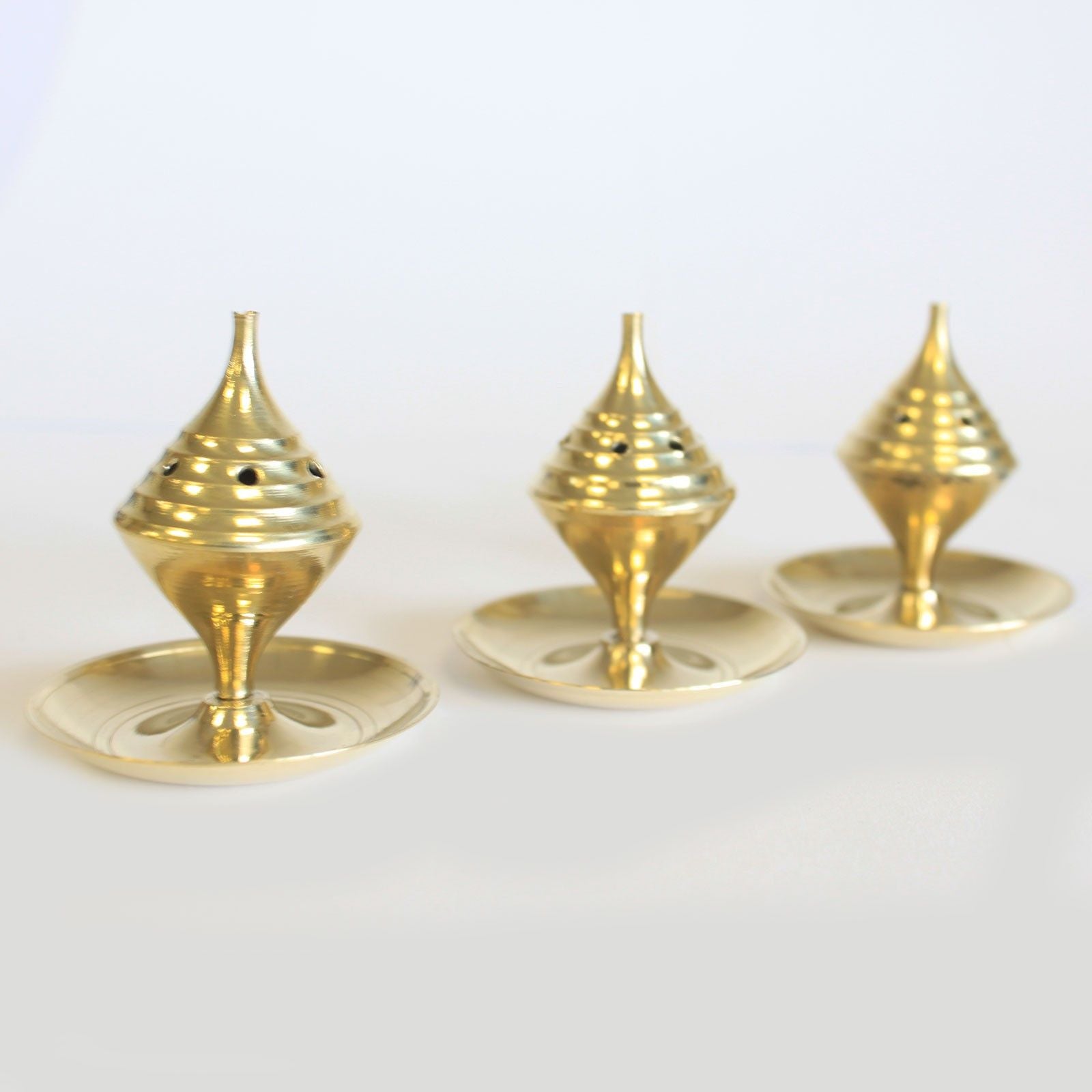 trois mini encensoirs en laiton posés côte à côte illustrant leur design traditionnel