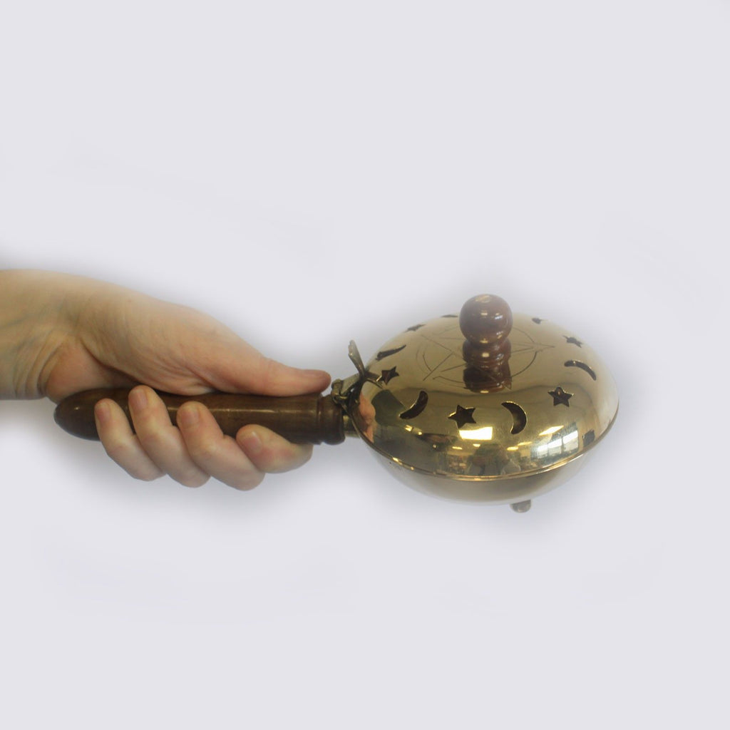 encensoir rituel en laiton avec manche bois tenu dans la main montrant sa taille