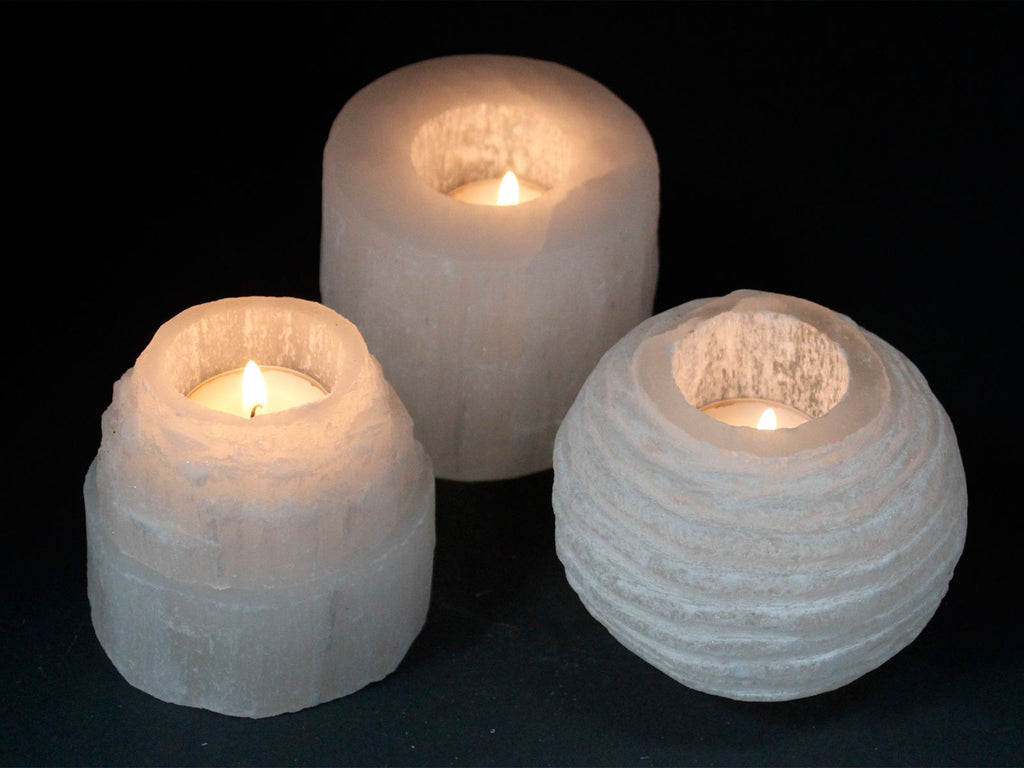 Plusieurs photophores en selenite allumes creant une ambiance zen et apaisante pour la maison