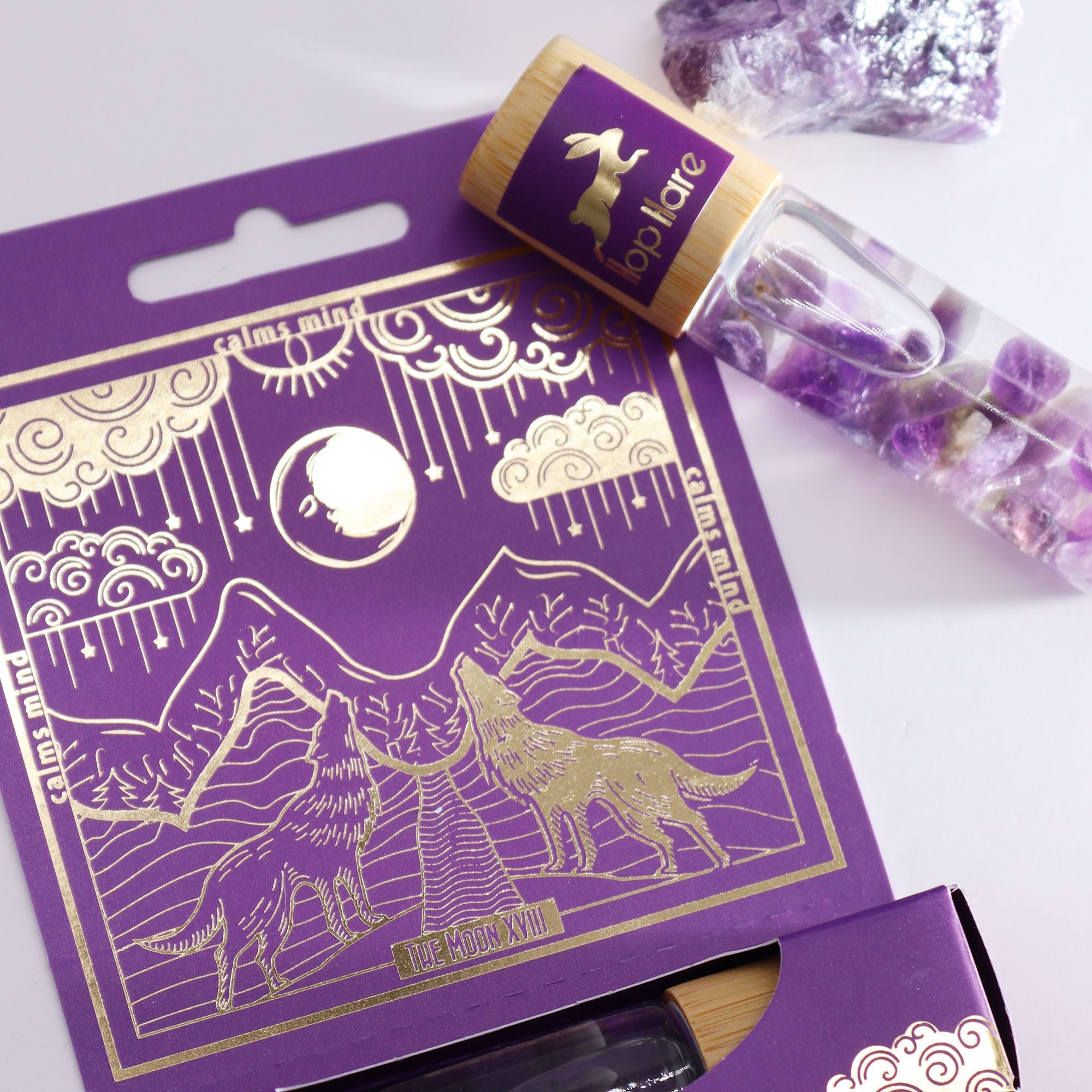 Roll-on La Lune aux huiles essentielles et pierre naturelle d’améthyste posé sur son coffret tarot.