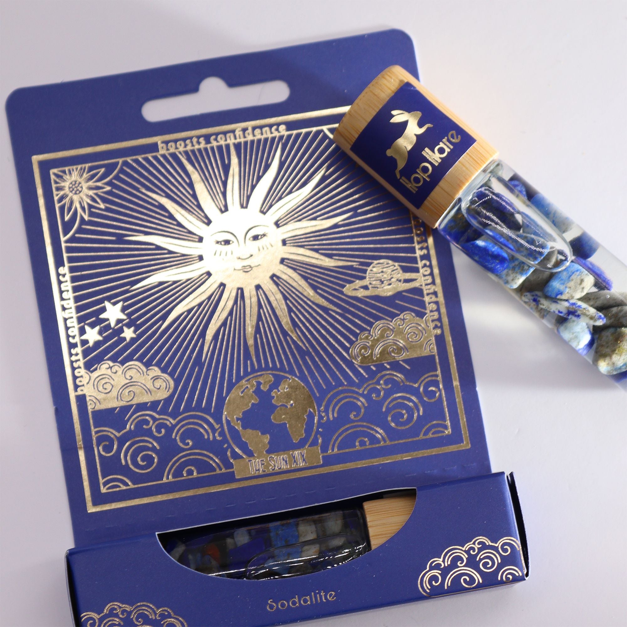 Roll-on Le soleil aux huiles essentielles et pierre naturelle de sodalite posé sur son coffret tarot.