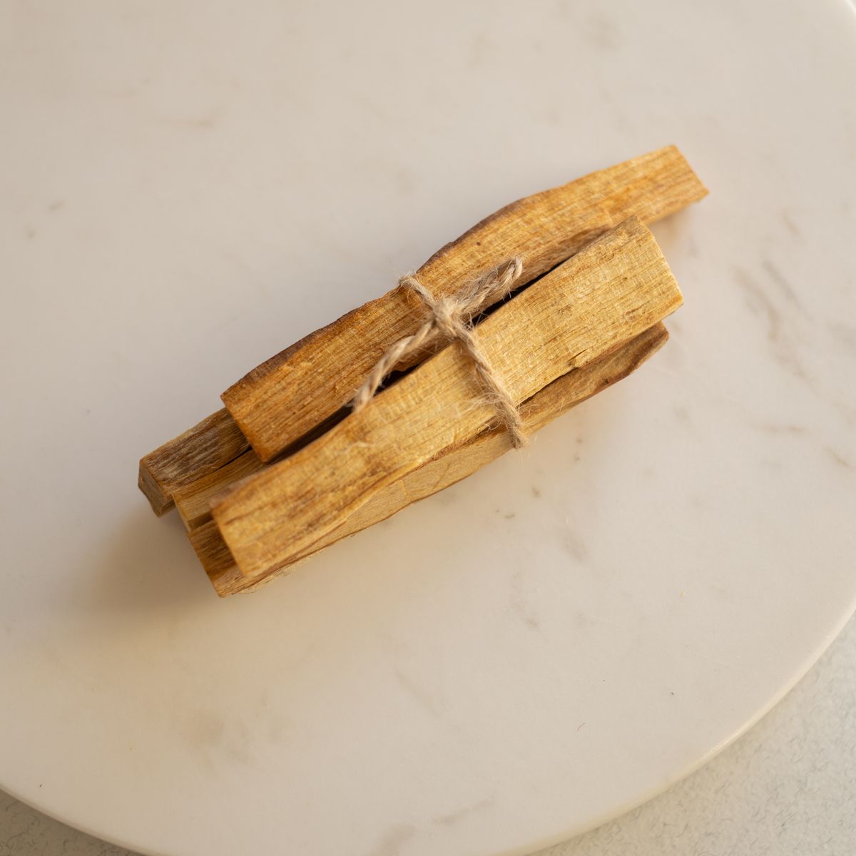 Bâtons de palo santo liés sur assiette en marbre