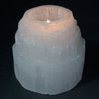 Photophore en selenite forme montagne avec bougie allumee diffusant une lumiere douce et apaisante