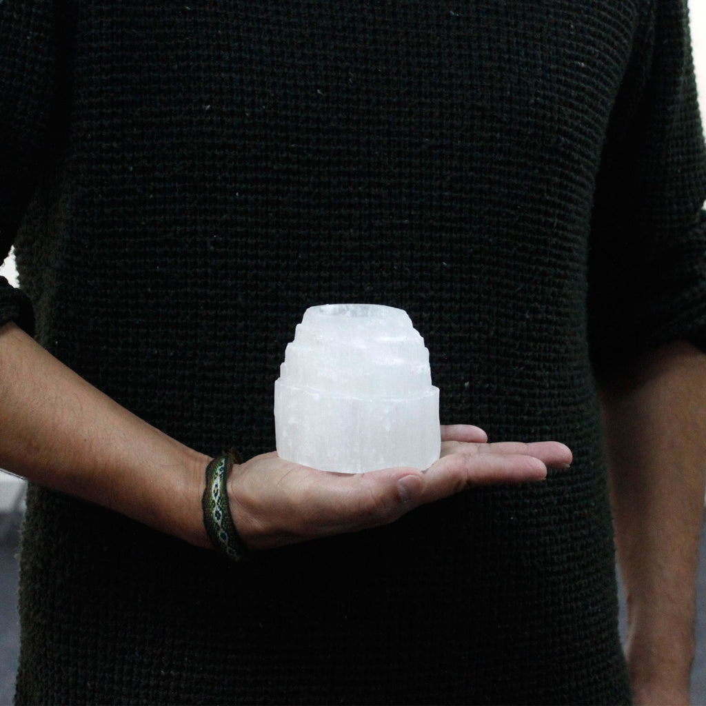 Photophore selenite montagne de petite taille tenu en main montrant son format compact et naturel