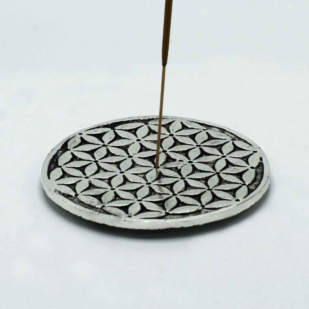 Porte-encens Fleur de Vie en métal avec bâton d’encens allumé, parfait pour rituel de purification, méditation et espace bien-être zen.