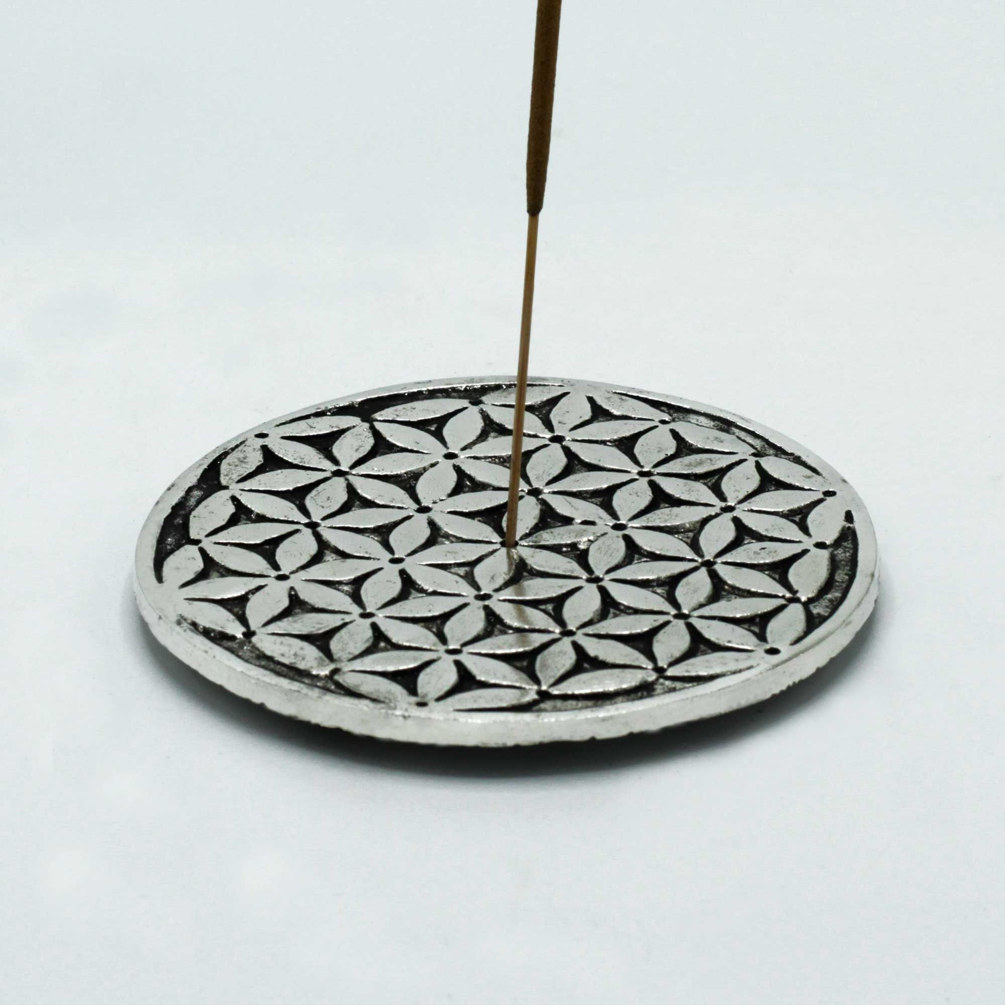 Porte-encens Fleur de Vie en métal avec bâton d’encens allumé, parfait pour rituel de purification, méditation et espace bien-être zen.