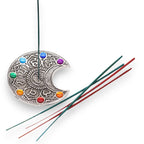 Porte-encens Lune 7 Chakras avec bâton d’encens allumé, utilisé pour méditation et harmonisation des centres énergétiques.