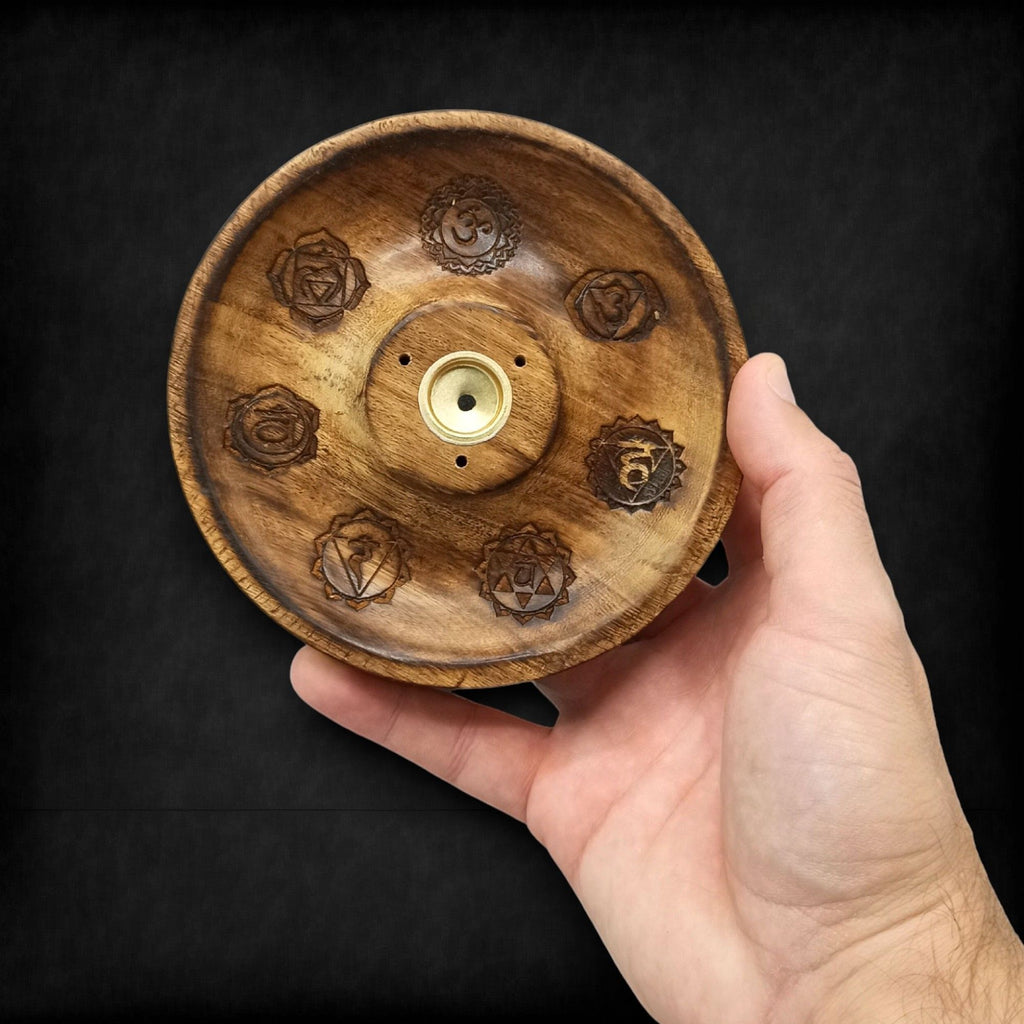 porte encens rond en bois naturel gravé des 7 chakras tenu dans la main montrant sa fabrication artisanale