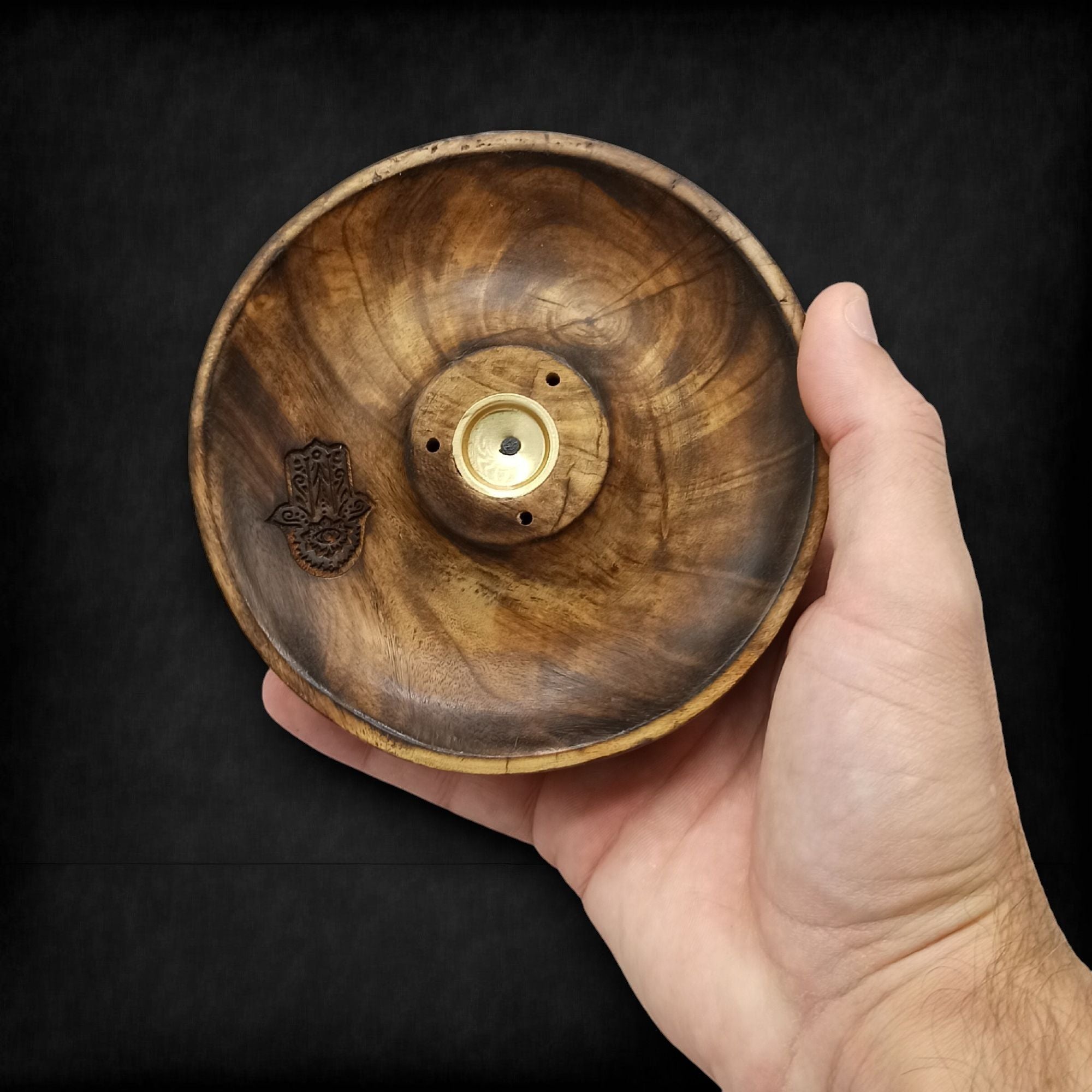 porte encens en bois naturel avec symbole hamsa gravé tenu dans la main montrant le support central pour bâtons et cônes d encens utilisé pour méditation et relaxation