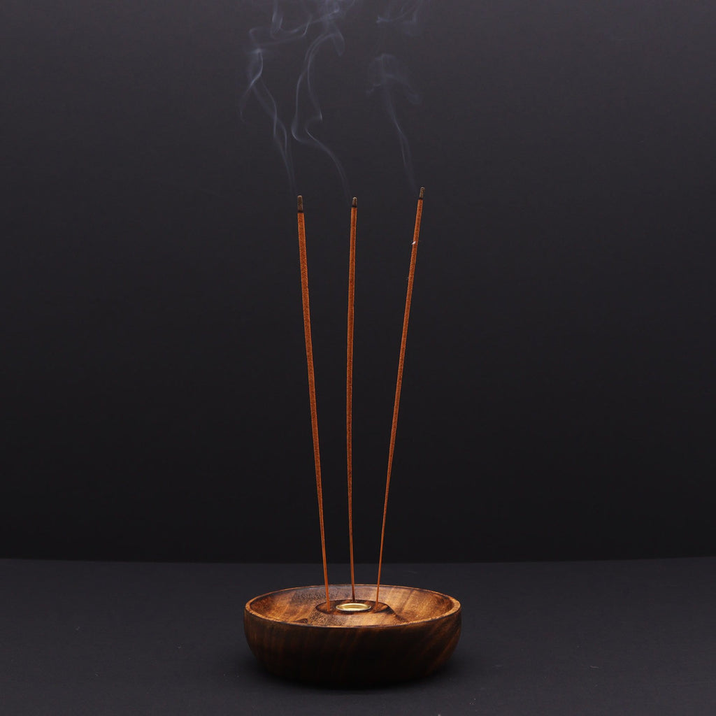 porte encens en bois naturel avec trois bâtons d encens allumés diffusant une fumée apaisante créant une ambiance zen et méditative