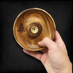 porte encens rond en bois naturel avec gravure bouddha tenu dans la main montrant sa fabrication artisanale
